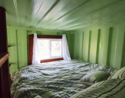 Upper bed area inside the tiny eco-friendly vacation rental at Da Fire Farm in Volcano, Hawaii